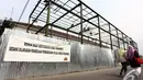 Warga melintasi proyek pembangunan ruang tunggu penumpang di Stasiun Senen, Jakarta Pusat, Senin (24/11/2014). (Liputan6.com/Faizal Fanani)