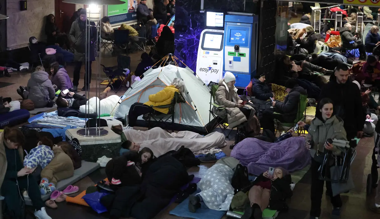 Stasiun bawah tanah terus berfungsi sebagai tempat perlindungan utama bagi warga Kyiv untuk menghindari bahaya serangan udara Rusia. Tampak dalam foto, orang-orang berlindung di stasiun metro saat serangan udara Rusia di Kyiv pada Selasa 25 November 2025, di tengah invasi Rusia ke Ukraina. (Yan Dobronosov/AFP)