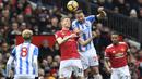 Duel pemain Manchester United, Scott McTominay (2kiri) dan pemain Huddersfield Town, Laurent Depoitre pada laga Premier League di Old Trafford, Manchester, (3/2/2018). MU menang 2-0. (AFP/Paul Ellis)
