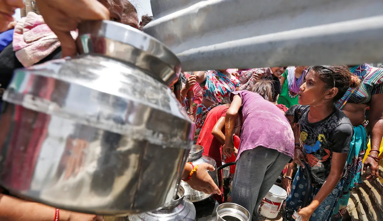 Warga saat berebut mengisi air kedalam ember mereka di pinggiran Ahmedabad , India 1 Juni 2016. Akibat gelombang panas ini, banyak sumur dan danau mengering yang mengakibatkan langkanya air di India. (REUTERS / Himanshu Sharma)