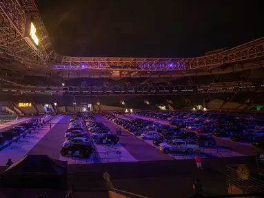 Orang-orang menonton film dari dalam mobil mereka di drive in yang dipasang di stadion sepak bola Palmeiras di Sao Paulo, Brasil, Kamis (25/6/2020). Stadion yang dapat menampung hingga 300 mobil tersebut berubah fungsi menjadi lokasi bioskop drive ini di masa pademi Covid-19. (AP Photo/Andre Penner)