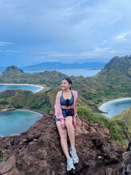 Prilly Latuconsina juga berlibur ke Labuan Bajo. Ia tampak mengenakan pakaian olahraga two pieces warna biru dipadukam outer pinknya. Credit:  (@prillylatuconsina96)