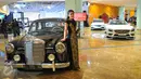 Model berpose di dekat mobil keluaran lama Mercedes Benz di Star Expo 2016,Jakarta, Rabu (23/11). Pameran tersebut merupakan pameran independen pertama dan terbesar bagi Mercedes Benz di Indonesia. (Liputan6.com/Angga Yuniar)