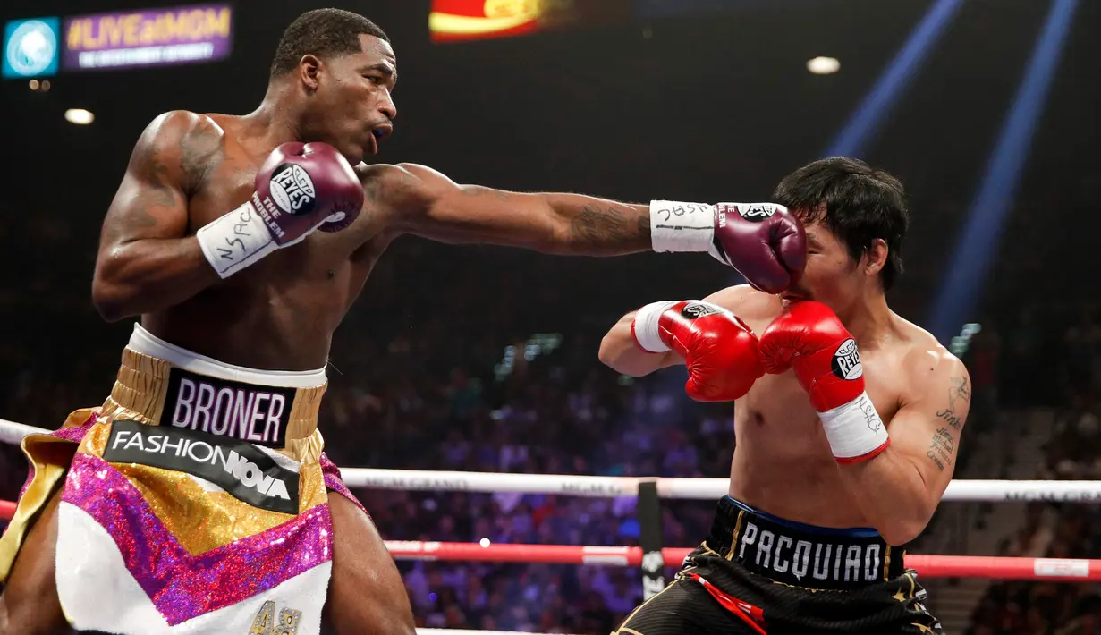 Petinju asal Filipina, Manny Pacquiao menghindari pukulan petinju AS, Adrien Broner selama pertandingan tinju kelas welter WBA di Las Vegas (19/1). Pacquiao  menang lewat kemenangan angka mutlak, 117-111, 116-112, dan 116-112. (AP Photo/John Locher)