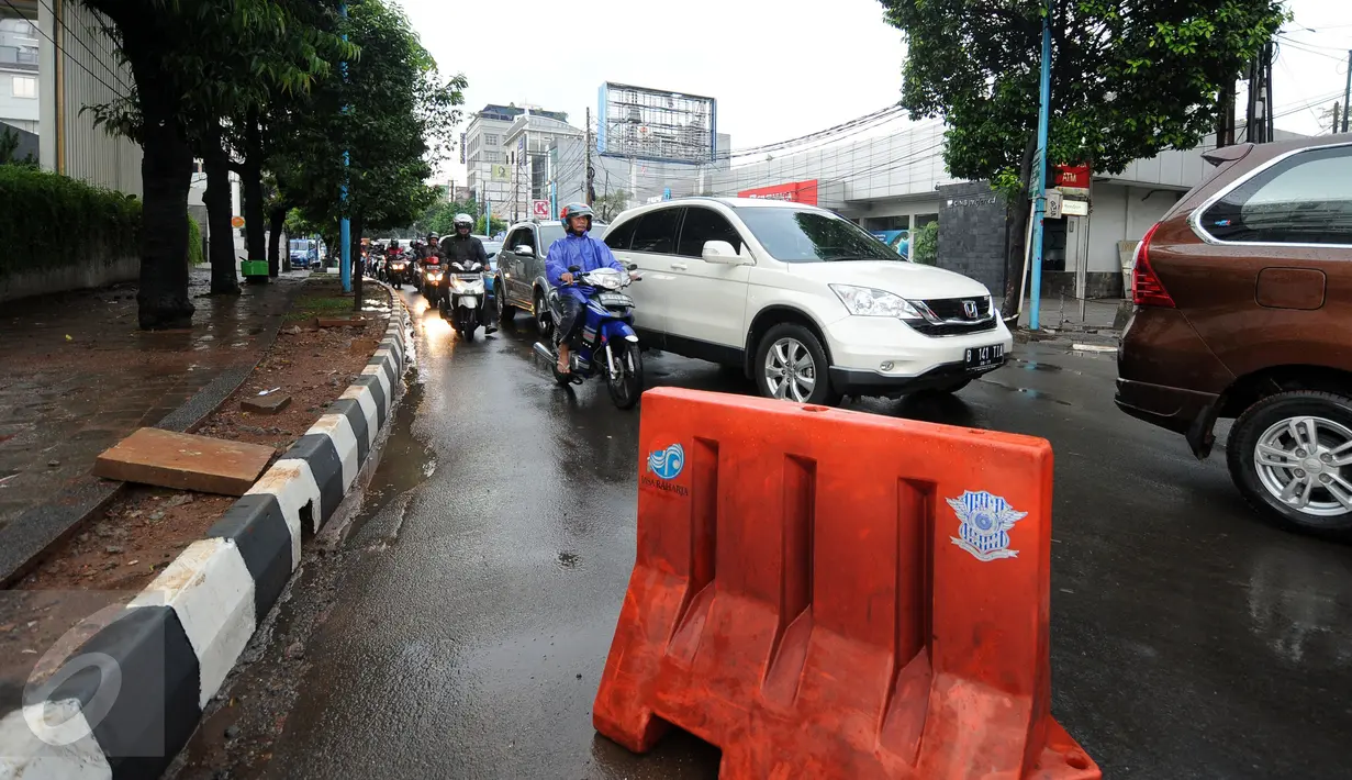 Pembatas jalan diletakkan menutup satu ruas Jalan Kemang Raya, Minggu (28/8). Penutupan terkait proses pengeringan lokasi parkir bawah tanah pertokoan akibat banjir yang terjadi sejak Sabtu malam (27/8). (Liputan6.com/Helmi Fithriansyah)