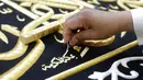 Pekerja menyulam kaligrafi Islam menggunakan benang berlapis emas pada tahap akhir pembuatan Kiswah Kabah di pabrik Kiswah di Mekah, Arab Saudi, Rabu (14/7/2021). Kiswah yang menutupi Kabah diganti setiap tahun untuk umrah atau haji. (AP Photo/Amr Nabil)