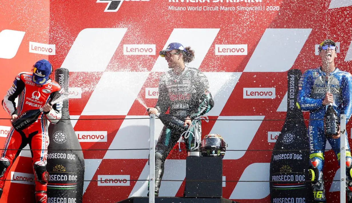 Pembalap Petronas Yamaha, Franco Morbidelli, melakukan selebrasi di atas podium usai menjuarai MotoGP San Marino di Sirkuit Misano, Minggu (13/9/2020). Morbidelli menjadi yang tercepat dengan catatan waktu 42 menit 02,272 detik. (AP/Antonio Calanni)