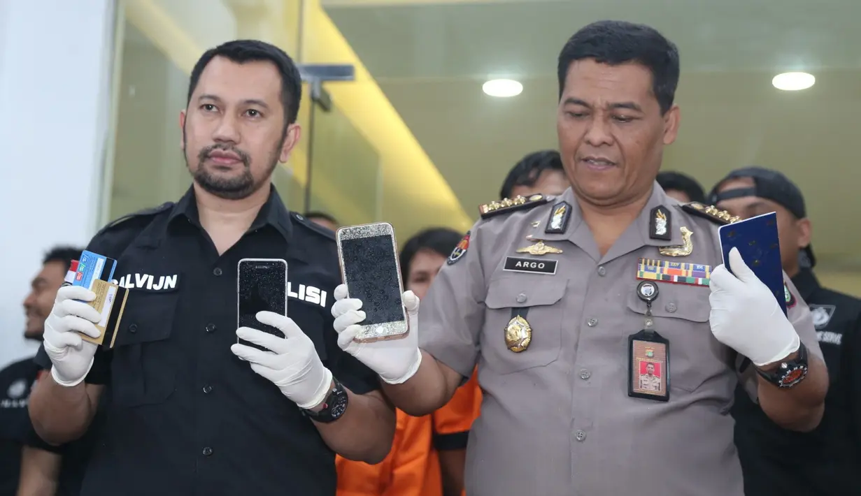 Polisi menunjukkan satu unit handphone (HP) sebagai barang bukti. HP disita sebagai alat komunikasi sabu. Selain itu, barang bukti buku tabungan atas nama RF dan juga kartu ATM yang dipergunakan untuk trensfer ke WH. (Nurwahyunan/Bintang.com)