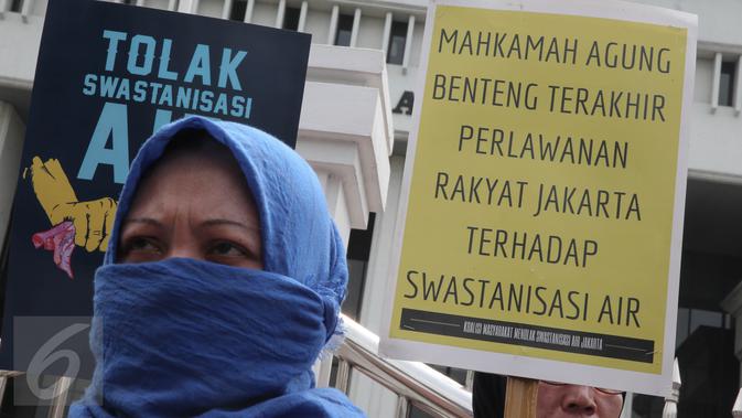 Seorang pendemo saat menggelar aksi membawa atribut poster menolak swastanisasi air Jakarta, di depan Gedung Mahkamah Agung, Jakarta, Jumat (3/6). Mereka meminta MA memutus secara adil dan bijak hak atas air. (Liputan6.com/Faizal Fanani)