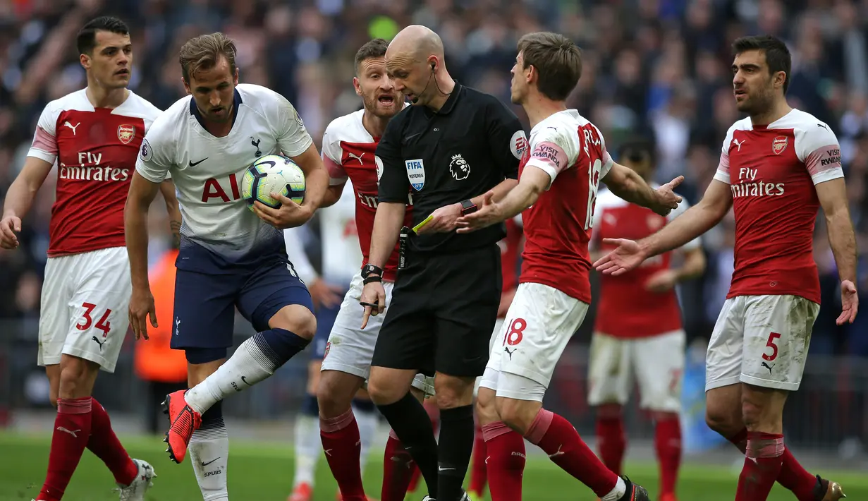 Para pemain Arsenal melakukan protes kepada wasit Anthony Taylor yang memberikan penalti kepada Tottenham pada laga Premier League di Stadion Wembley, London, Sabtu (2/3). Kedua klub bermain imbang 1-1. (AFP/Daniel Leal-Olivas)