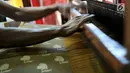 Pengrajin saat menyelesaikan pembuatan tenun ikat di salah satu industri rumahan di Desa Bandar Kidul, Kediri, Jawa Timur, Sabtu (29/9). Industri rumahan ini mulai bermunculan pascapabrik-pabrik saudagar China dan Arab tutup. (Merdeka.com/Iqbal Nugroho)