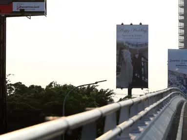Pengendara motor melintasi sebuah billboard ucapan pernikahan di jalan layang Tanjung Barat, Jagakarsa, Jakarta, Kamis (21/9). Papan iklan itu memuat satu pasangan bernama Nafisa dan Rizky. (Liputan6.com/Immanuel Antonius)