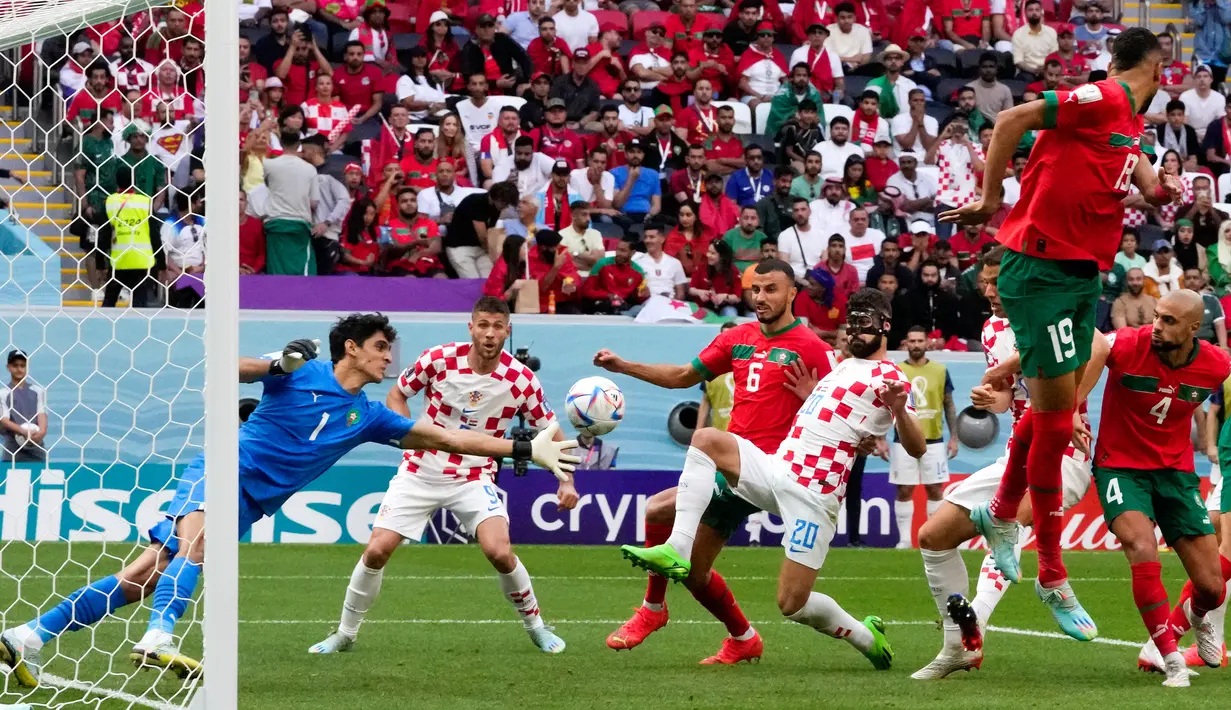 Kiper Maroko Yassine Bounou (1) mencoba menepis bola saat pemain Kroasia Josko Gvardiol (20) menyerang pada pertandingan sepak bola Grup F Piala Dunia 2022 di Stadion Al Bayt, Al Khor, Qatar, Rabu (23/11/2022). Pertandingan berakhir imbang dengan skor 0-0. (AP Photo/Themba Hadebe)