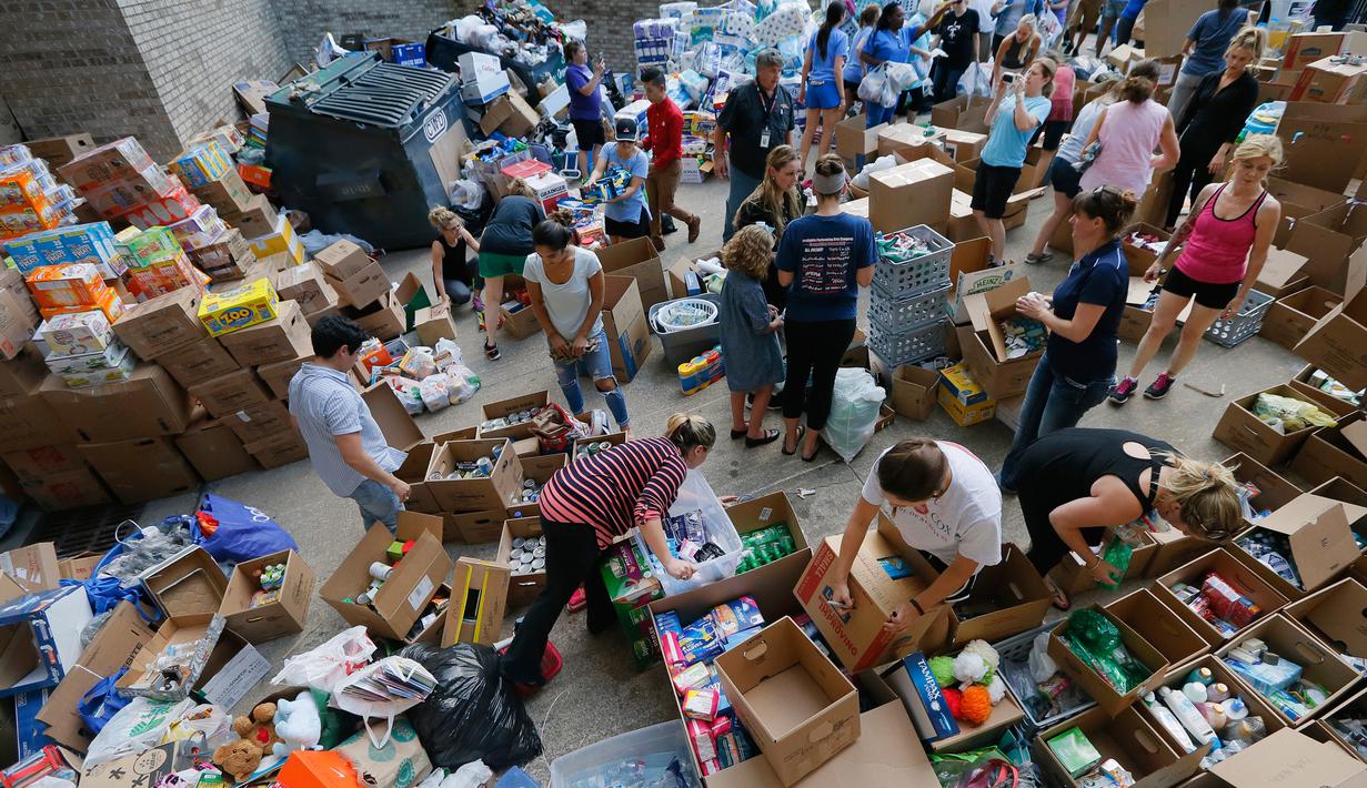 Para relawan mengatur bermacam barang hasil penggalangan dana untuk korban Harvey di Dallas Utara, Selasa (29/8). Para donatur bisa memberikan bantuan berupa barang atau uang melalui situs milik Charity Navigator. (Tony Gutierrez/AP)