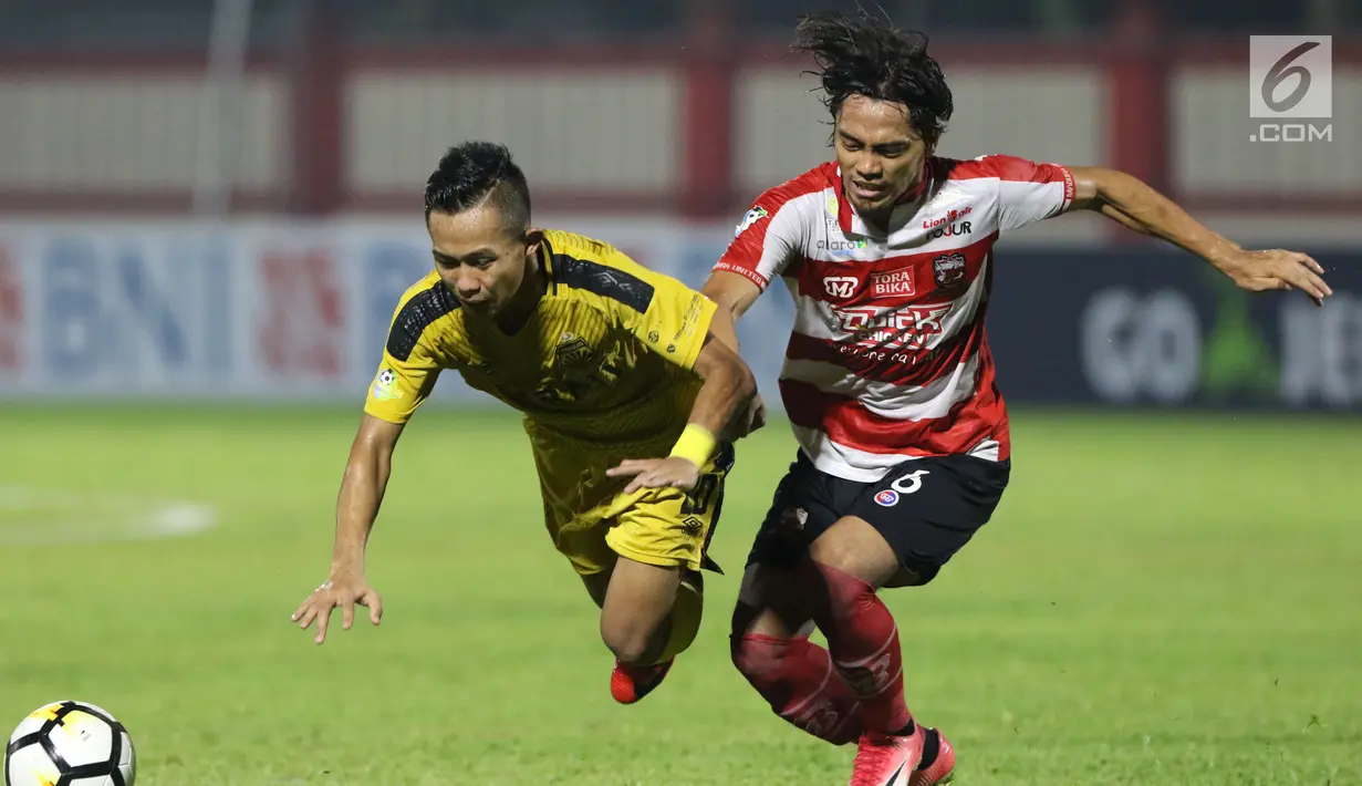 Pemain depan Bhayangkara FC, Sani Rizki Fauzi (kiri) berebut bola dengan Bek Madura United, Andik Rendika Rama pada lanjutan Go-Jek Liga 1 Indonesia 2018 bersama Bukalapak di Stadion PTIK, Jakarta, Kamis (7/6). (Liputan6.com/Helmi Fithriansyah)