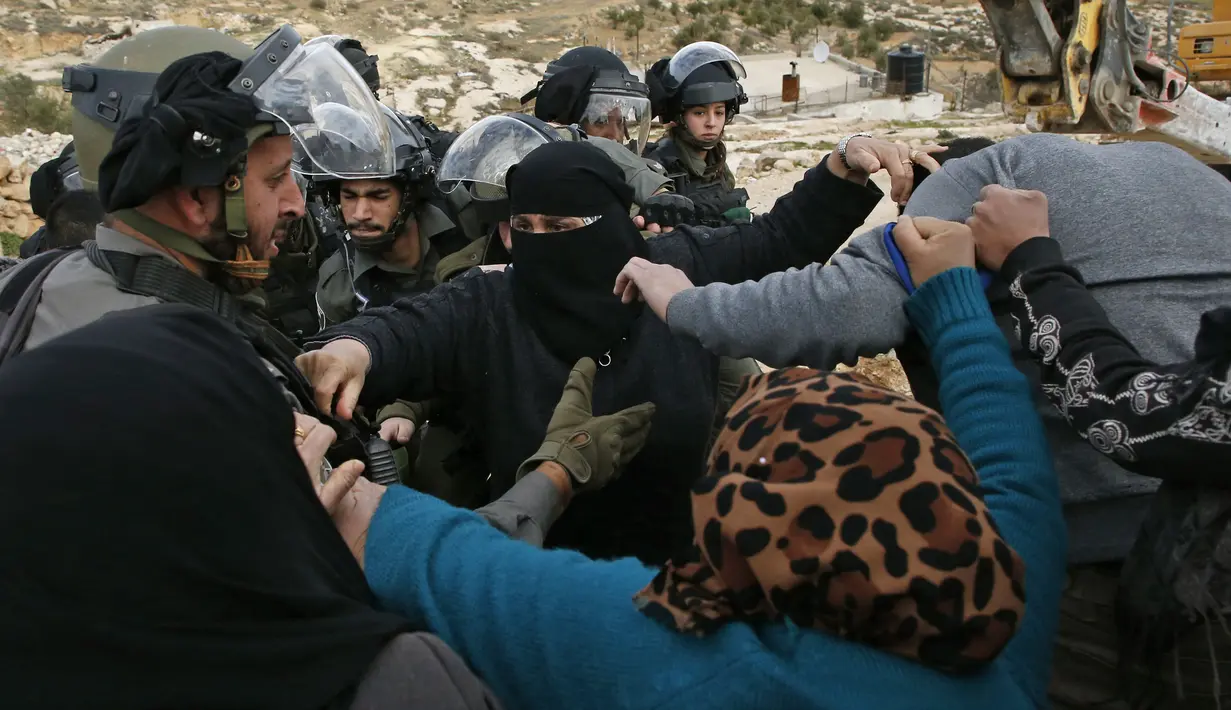 Perempuan Palestina terlibat cekcok dengan polisi Israel saat memprotes pembongkaran rumah di Desa Al-Dirat, dekat kota Hebron, Tepi Barat (16/1/2020). Pembongkaran itu menurut otoritas Israel dilakukan karena rumah dibangun tanpa izin. (AFP/Hazem Bader)