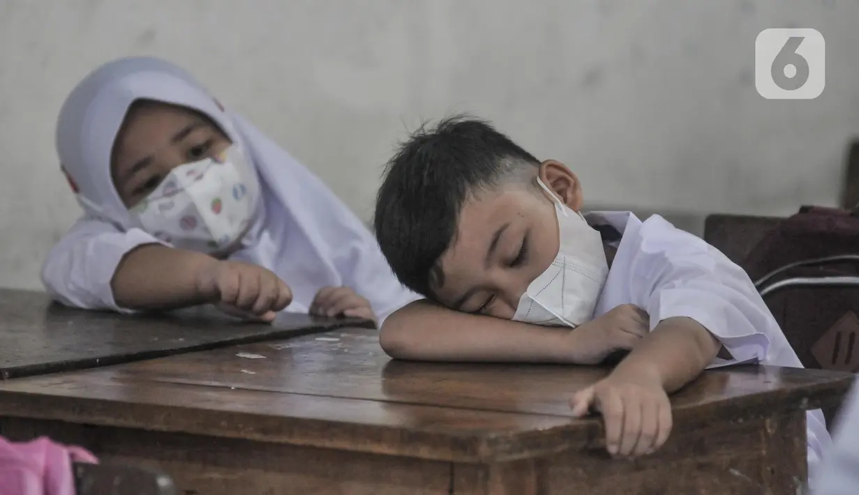 Murid kelas 1 tertidur saat Masa Pengenalan Lingkungan Sekolah (MPLS) di Sekolah Dasar (SD) Negeri Jati 06 Pagi, Pulogadung, Jakarta Timur, Senin (11/7/2022). PTM 100 persen tetap disiplin menerapkan protokol kesehatan guna mencegah penyebaran Covid-19 di lingkungan sekolah. (merdeka.com/Iqbal S. Nugroho)