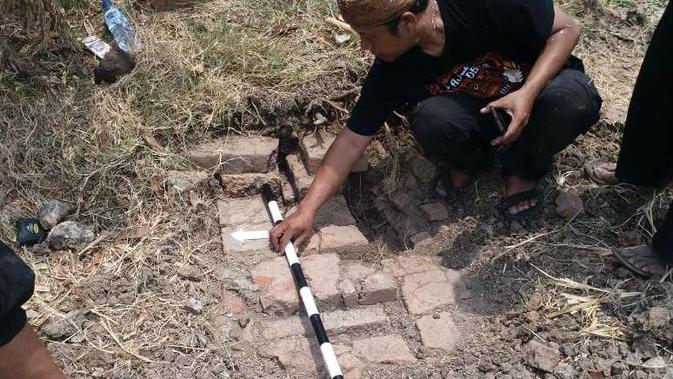 Mengukur temuan struktur susunan batu bata menyerupai candi. Foto (Liputan6.com / Panji Prayitno)