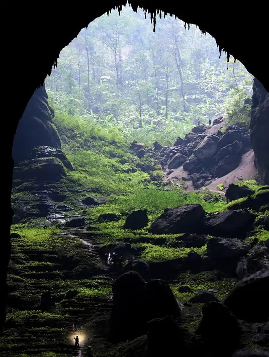 Foto pada 18 Januari 2021 menunjukkan seorang pengunjung di gua Son Doong, salah satu gua alam terbesar di dunia, selama tur di provinsi Quang Binh, Vietnam. Wisatawan bisa menemukan stalagmit setinggi 70 cm hingga hutan yang berada di dalam gua ini. (Nhac NGUYEN/AFP)