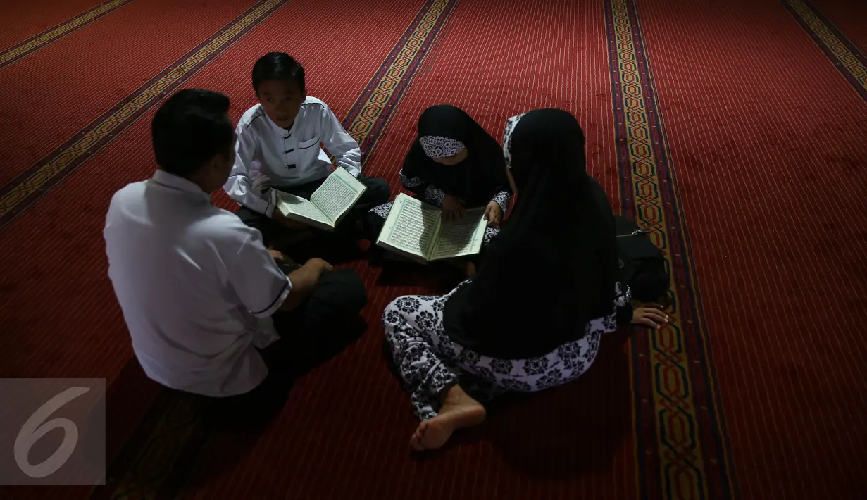 Sebuah keluarga membaca kitab suci Alquran pada bulan Ramadan 1437 H di Masjid Istiqlal, Jakarta, Jumat (7/1). Bulan Ramadan merupakan momentum bagi umat Islam untuk memperbanyak ibadah. (Liputan6.com/Faizal Fanani)