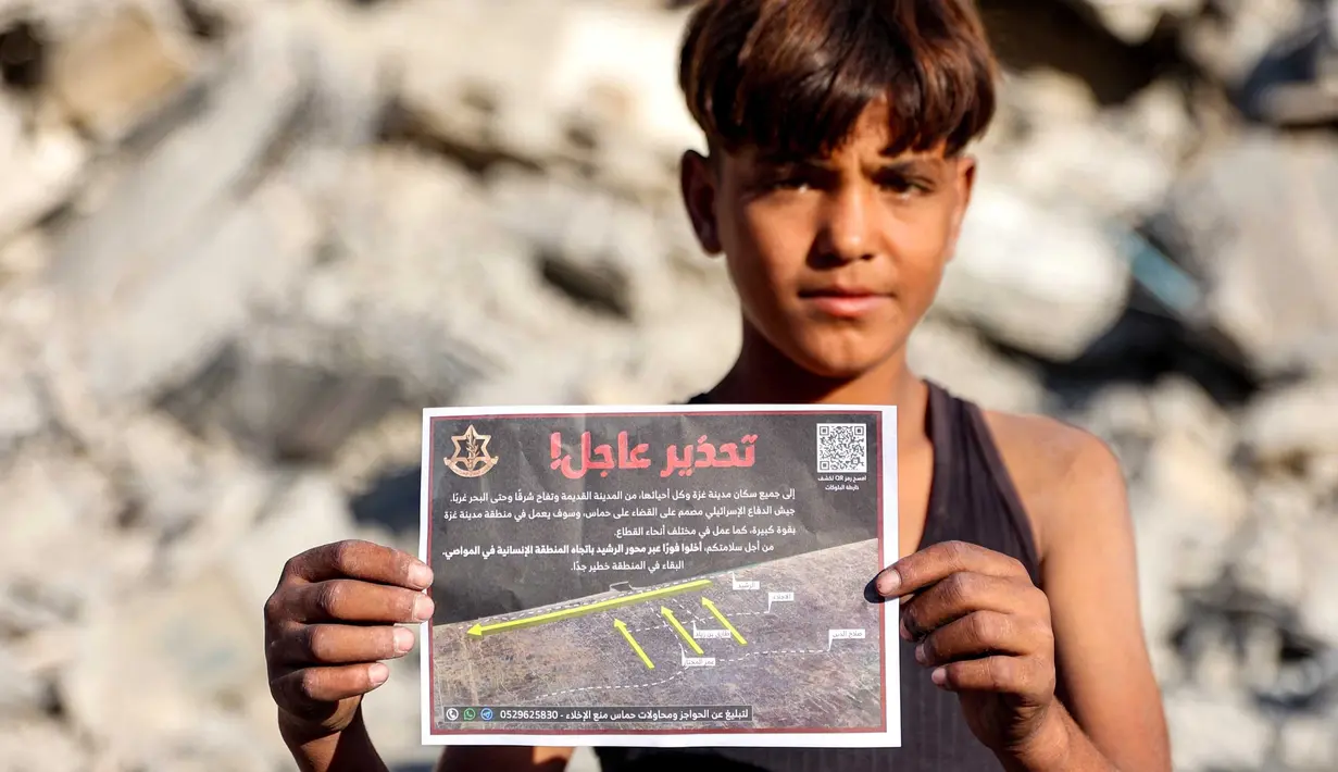 Seorang anak laki-laki memegang salah satu selebaran yang dijatuhkan oleh militer Israel di Kota Gaza, yang menyerukan evakuasi ke selatan menuju al-Mawasi, pada 9 September 2025. (Omar AL-QATTAA/AFP)