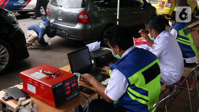 Petugas memeriksa emisi kendaraan di Jakarta Barat, Rabu (13/1/2021). Dinas Lingkungan Hidup DKI Jakarta mengumumkan kendaraan yang tidak mengikuti uji emisi atau tidak lulus uji emisi gas buang akan dikenakan disinsentif tarif parkir yang tinggi dan tilang. (Liputan6.com/Angga Yuniar)