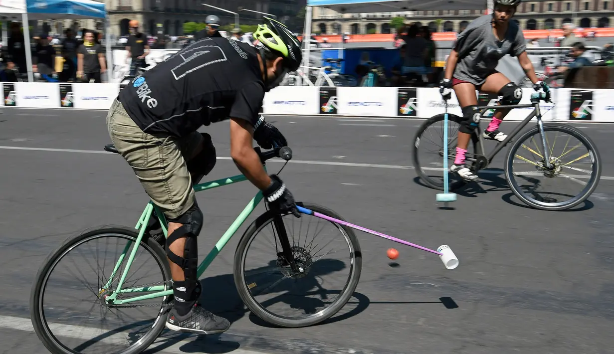 Seorang pria memacu sepeda saat bermain Polo-Bike pada hari kedua World Bike Forum 2017 di Zocalo Square di Mexico City (20/4). World Bike Forum adalah ajang berkumpulnya para pengguna dan penggiat sepeda di kota-kota besar. (AFP Photo/Alfredo Estrella)