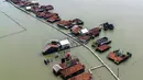 Penurunan tanah (land subsidence), kenaikan muka air laut akibat perubahan iklim, dan kurang maksimalnya mitigasi/infrastruktur pertahanan pesisir menjadi beberapa penyebab semakin tenggelamnya Desa Timbulsloko di Sayung, Demak, Jawa Tengah. Tampak dalam foto, pemandangan udara menunjukkan rumah-rumah yang sebagian terendam air laut akibat banjir pasang surut di sepanjang pantai selatan Laut Jawa di desa Timbulsloko, Demak, Jawa Tengah pada Sabtu 18 April 2026. (DEVI RAHMAN/AFP)
