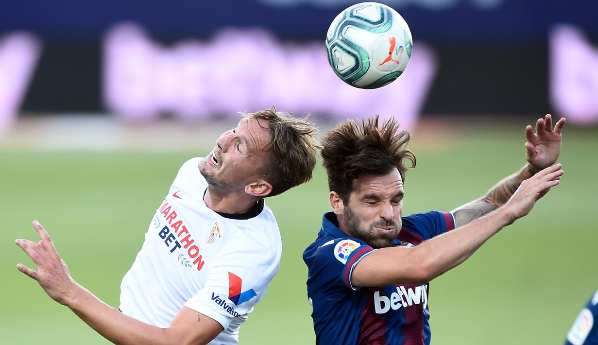 Bek Levante, Tono, duel udara dengan pemain Sevilla, Luuk De Jong, pada laga La Liga di Estadio Camilo Cano, Selasa (16/6/2020). Kedua tim bermain imbang 1-1. (AFP/Jose Jordan)