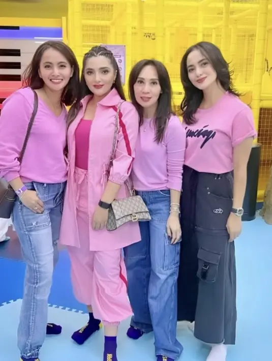 Ririn Ekawati tampil mengenakan atasan tshirt pink dengan aksen tulisan hitam dipadukan celana hitam yang memiliki kantung depan. [@liliriana]