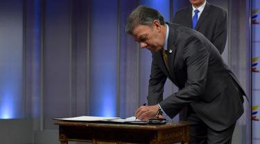Presiden Kolombia Juan Manuel Santos menandatangani SK melegalkan penggunaan ganja untuk keperluan medis dan ilmiah, di Bogota, Selasa (22/12). SK itu mengatur budidaya, pengolahan, impor dan ekspor ganja untuk tujuan terapeutik (AFP/Presidencia Colombia)