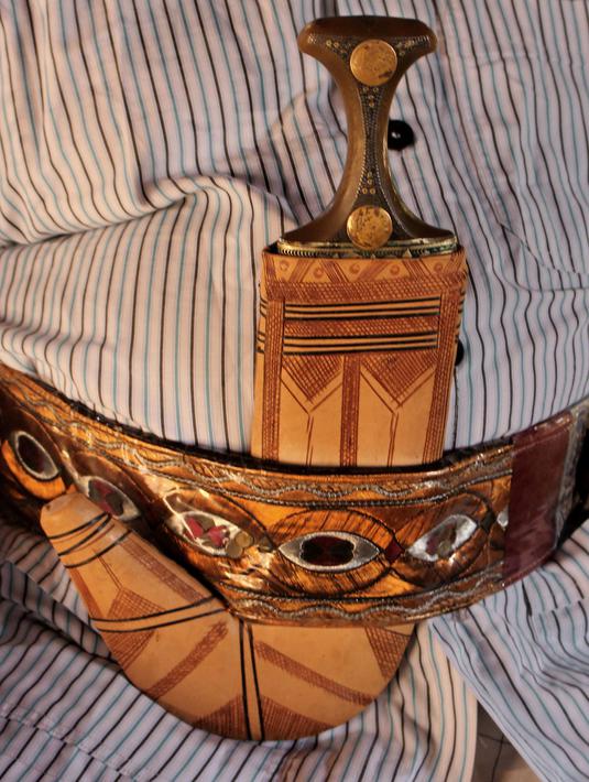 Foto 6 Oktober 2018, seorang pria menyelipkan pisau tradisional, jambiya, di sabuknya di Hajjah, Yaman. Mereka mengumpulkan serpihan logam sisa-sisa dari rudal yang ditembakkan Koalisi Arab Saudi dan mengubahnya menjadi belati jambiya. (AP/Hammadi Issa)