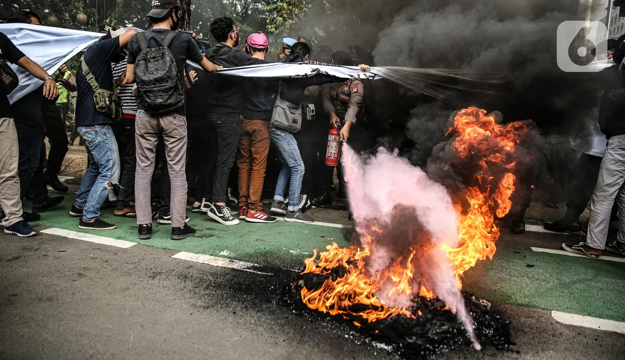 Massa yang tergabung dalam gerakan nasional tolak reklamasi (Gentar) membakar ban saat aksi didepan Gedung Balaikota, Jakarta, Rabu (8/7/2020). Reklamasi Pantai Ancol dianggap sebagai bentuk perampasan pantai publik atas akses masyarakat nelayan pesisir Jakarta.  (Liputan6.com/Faizal Fanani)