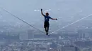 Alexander Schultz berjalan di atas tali sepanjang 217 meter yang menghubungkan dua gedung tertinggi Mexico City di Meksiko, 4 Desember 2016. Schultz butuh lima kali upaya menaklukkan tali yang dipasang pada ketinggian 246 meter tersebut (REUTERS/Stringer)