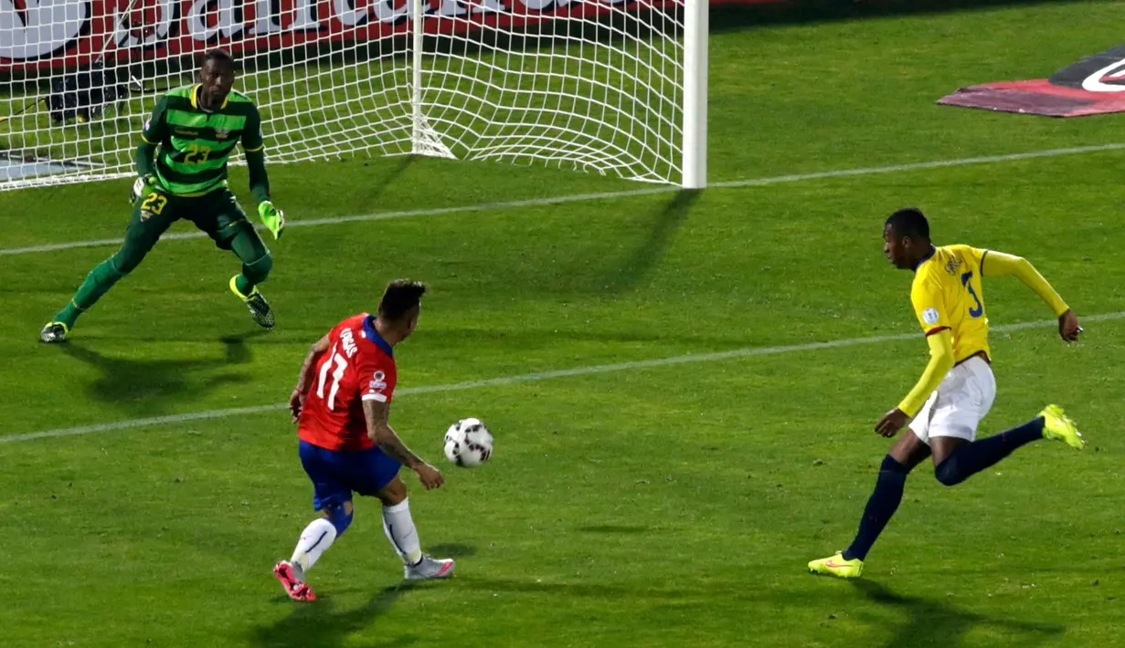 Penyerang Chile, Eduardo Vargas (tengah) menendang bola ke arah kiper Ekuador, Alexander Dominguez pada pertandingan pembukaan Copa America 2015 di National Stadium, Santiago, Chile, (11/6/2015). Chile menang 2-0 atas Ekuador. (REUTERS/Ueslei Marcelino)