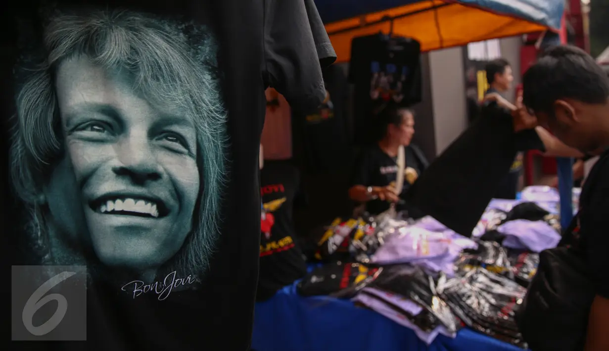Pengunjung saat melihat kaos Bon Jovi yang dijajakan pedagang di luar Stadion Gelora Bung Karno, Jakarta, Jumat (11/9/2015). Grup band asal Amerika itu akan menggelar konser ‘Bon Jovi Live! Jakarta' nanti malam di arena GBK. (Liputan6.com/Faizal Fanani)