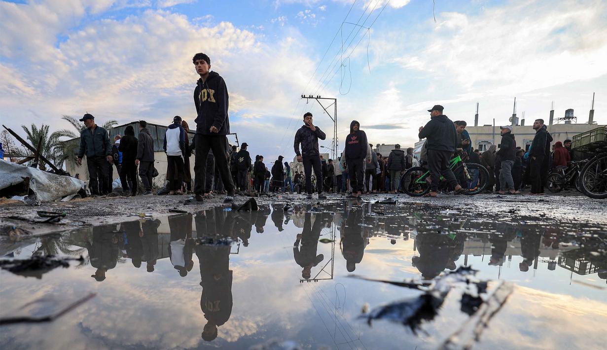 Sebelum serangan, militer Israel mengklaim telah mengeluarkan perintah evakuasi untuk area tersebut. Tampak dalam foto, warga memeriksa kerusakan akibat udara Israel menghantam sebuah lokasi dekat tenda-tenda penampungan pengungsi Palestina di Deir el-Balah, Jalur Gaza tengah pada 25 Maret 2026. (Eyad Baba/AFP)