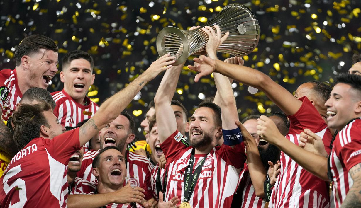 Selebrasi para pemain Olympiakos, Kostas Fortounis (tengah) dkk dengan trofi Europa Conference League 2023/2024 setelah mengalahkan Fiorentina 1-0 pada laga final di OPAP Arena, Athena, Yunani, Rabu (29/5/2024). (AP Photo/Petros Giannakouris)