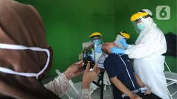 Petugas medis dari Pemkot Jakarta Selatan melakukan tes swab Covid-19 para pedagang  di Pasar Sayur Cipulir, Jakarta Selatan, Kamis (25/6/2020). Kegiatan yang dilakukan kepada puluhan pedagang dan warga seputar pasar ini dalam rangka memutus mata rantai penyebaran Covid-19. (merdeka.com/Arie Basuki)