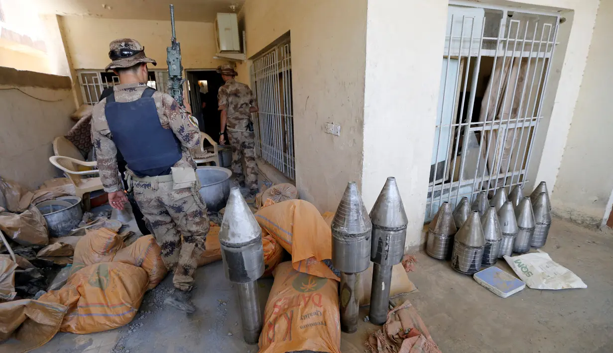 Anggota pasukan kontraterorisme Irak memeriksa bangunan yang digunakan sebagai pabrik senjata militan ISIS yang berhasil ditemukan di Fallujah, Irak, Kamis (23/6). (REUTERS/Thaier Al-Sudani)