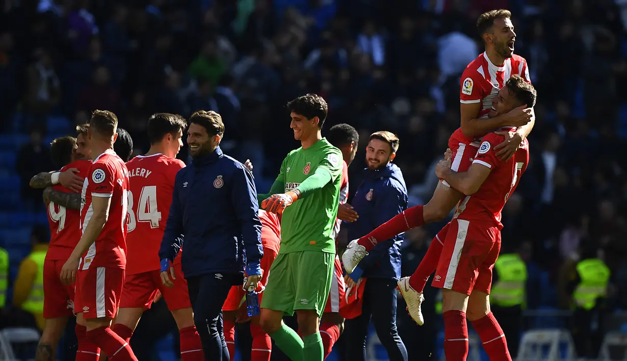 Para pemain Girona merayakan kemenangan atas Real Madrid pada laga La Liga di Stadion Santiago Bernabeu, Madrid, Minggu (17/2). Madrid kalah 1-2 dari Girona. (AFP/Gabriel Bouys)
