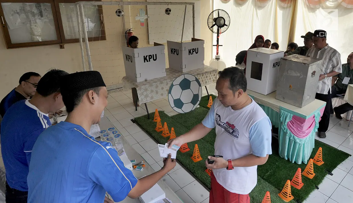 Warga menerima surat suara untuk mencoblos pada pelaksanaan Pilkada Serentak 2018 di TPS 31 Mutiara Sentul, Bogor, Rabu (27/6). TPS ini didekorasi dengan konsep piala dunia untuk menarik minat pemilih agar hadir dalam pencoblosan (Merdeka.com/Arie Basuki)