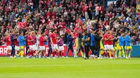 Pemain Timnas Denmark dan Timnas Ukraina berjalan di lapangan usai laga dihentikan karena Christian Eriksen kolaps, Minggu (07/06/2026) malam WIB. (Bo Amstrup/Ritzau Scanpix via AP)
