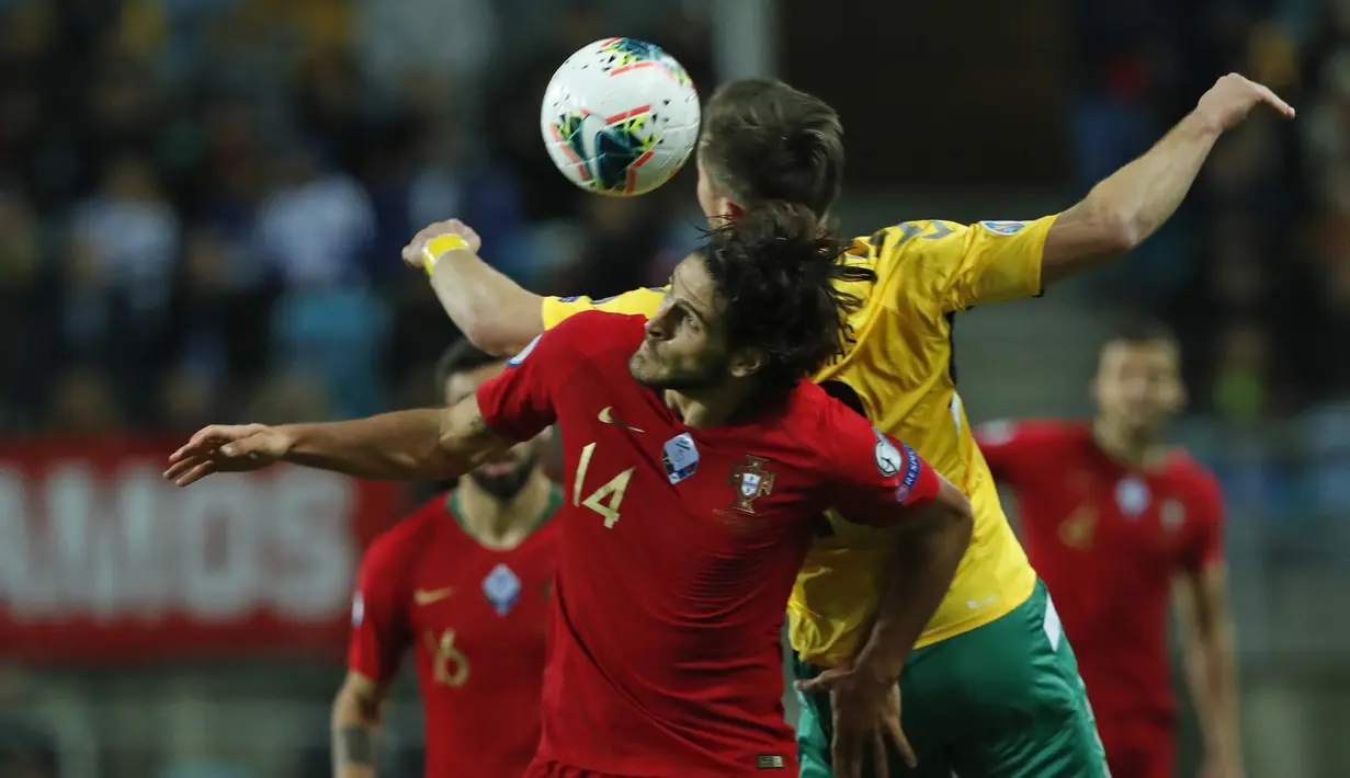 Penyerang Portugal, Goncalo Paciencia berebut bola udara dengan pemain Lithuania, Saulius Mikoliunas pada pertandingan Grup B Kualifikasi Piala Eropa 2020 di stadion Algarve di luar Faro, Portugal (14/11/2019). Portugal menang besar 6-0 atas Lithuania. (AP Photo/Armando Franca)