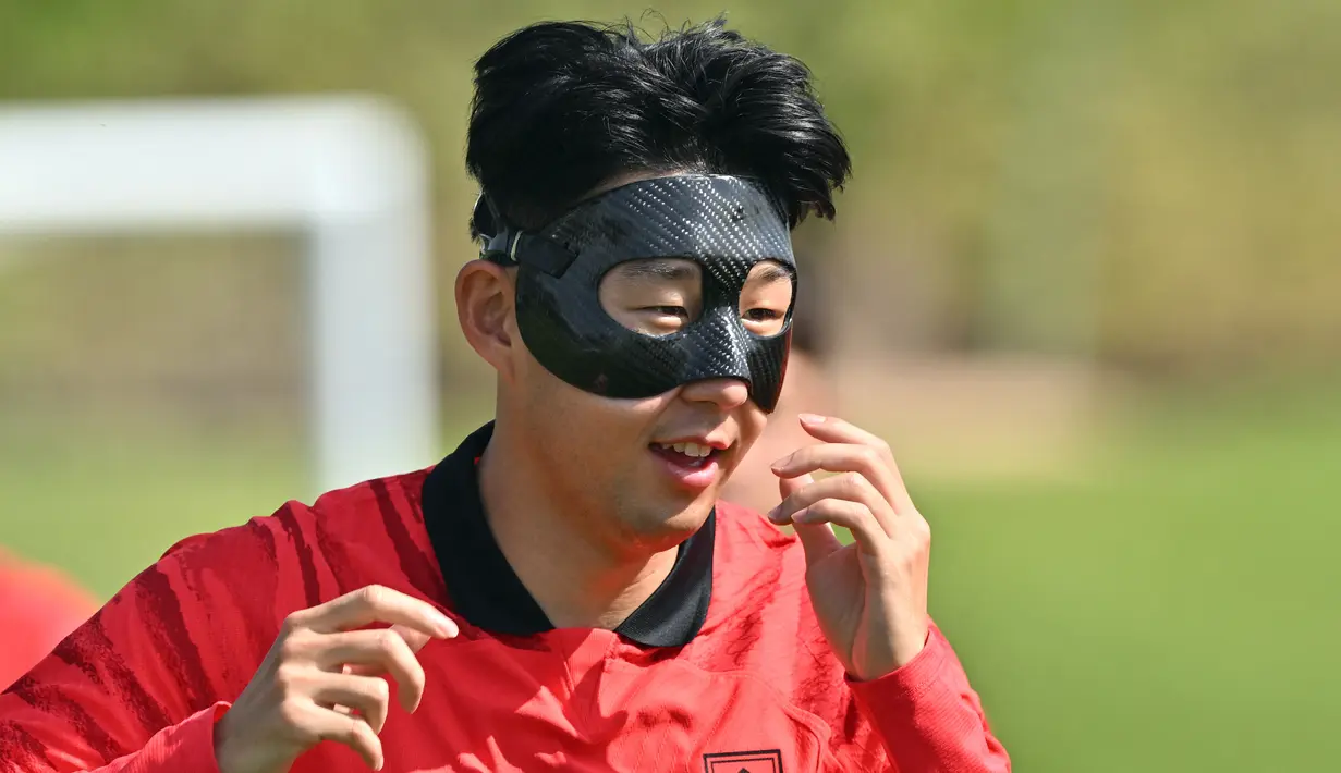 Kapten timnas Korea Selatan (Korsel) Son Heung-min mengenakan masker pelindung saat mengikuti sesi latihan di Al Egla Training Site 5 di Doha, Rabu (16/11/2022). Pulih dari cedera wajah, Son Heung-min mengenakan masker pelindung selama sesi latihan pertamanya dengan tim nasional menjelang dimulainya Piala Dunia 2022 Qatar. (Jung Yeon-je / AFP)