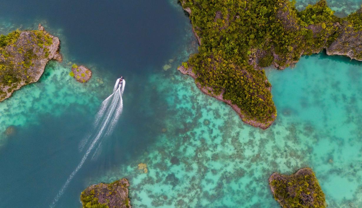 Sebuah speedboat melintasi kepulauan Waigeo Barat, Raja Ampat, Papua Barat Daya, Kamis 5 Maret 2026. Sebagai salah satu perairan dengan flora dan fauna terlengkap di dunia, Raja Ampat, memiliki hampir 75% terumbu karang dunia, lebih dari 1.000 jenis ikan, dan 700 jenis moluska. (AP Photo/Claudia Rosel)