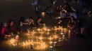 Orang-orang mengambil bagian dalam perayaan Hari Raya Lilin Kecil di Medellin, Kolombia (7/12). Selama perayaan Immaculate Conception of the Virgin Mary, orang menyalakan lilin di rumah mereka dan di lampu jalan di Kolombia. (AFP Photo/Joaquin Sarmiento)