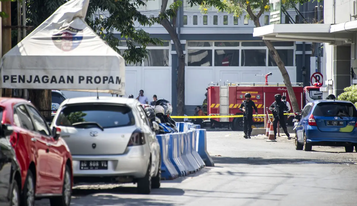 Aparat kepolisian menutup jalan setelah serangan bom bunuh diri di Polrestabes Surabaya, Jawa Timur, Senin (14/5). Pelaku yang mengendarai motor meledakan bom di depan Polrestabes Surabaya, tepat di pintu masuk. (AFP/JUNI KRISWANTO)