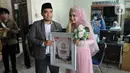 Sepasang pengantin yang menikah pada tanggal cantik hari ini di KUA Pamulang, Tangerang Selatan, Selasa (22/2/2022). Sebanyak 10 pasangan menjalankan akad nikah di KUA Pamulang pada hari ini yang dianggap memiliki tanggal cantik. (merdeka.com/Arie Basuki)