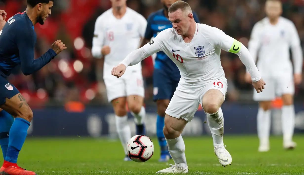 Striker Inggris, Wayne Rooney berusaha melewati pemain AS, Matt Miazga selama pertandingan persahabatan di Stadion Wembley, Inggris (16/11). Rooney yang sebenarnya sudah pensiun pada 2016. (AP Photo/Alastair Grant)